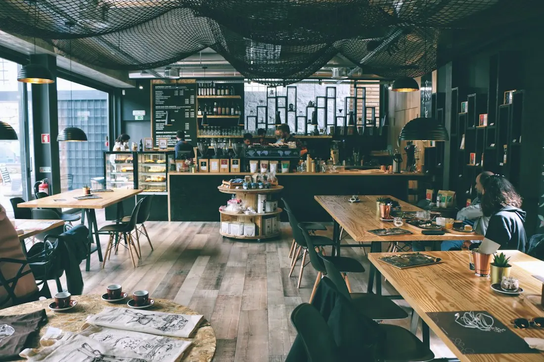 Inside the café: wooden tables, green walls and plants